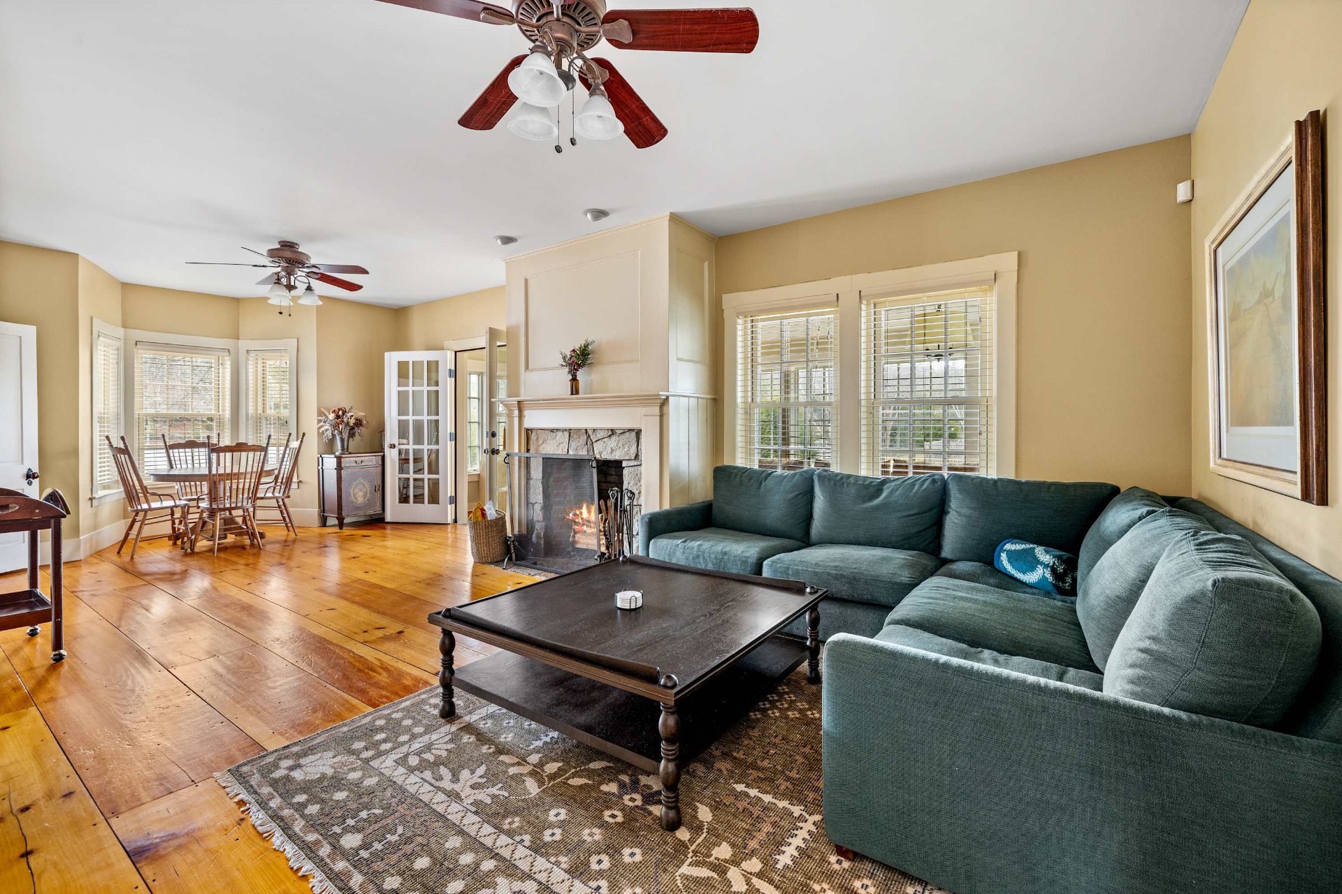 Farmhouse living room with stone fireplace and wide pine floors